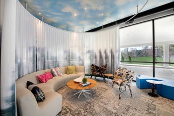 a living room with white curtains and a blue sky on the ceiling
